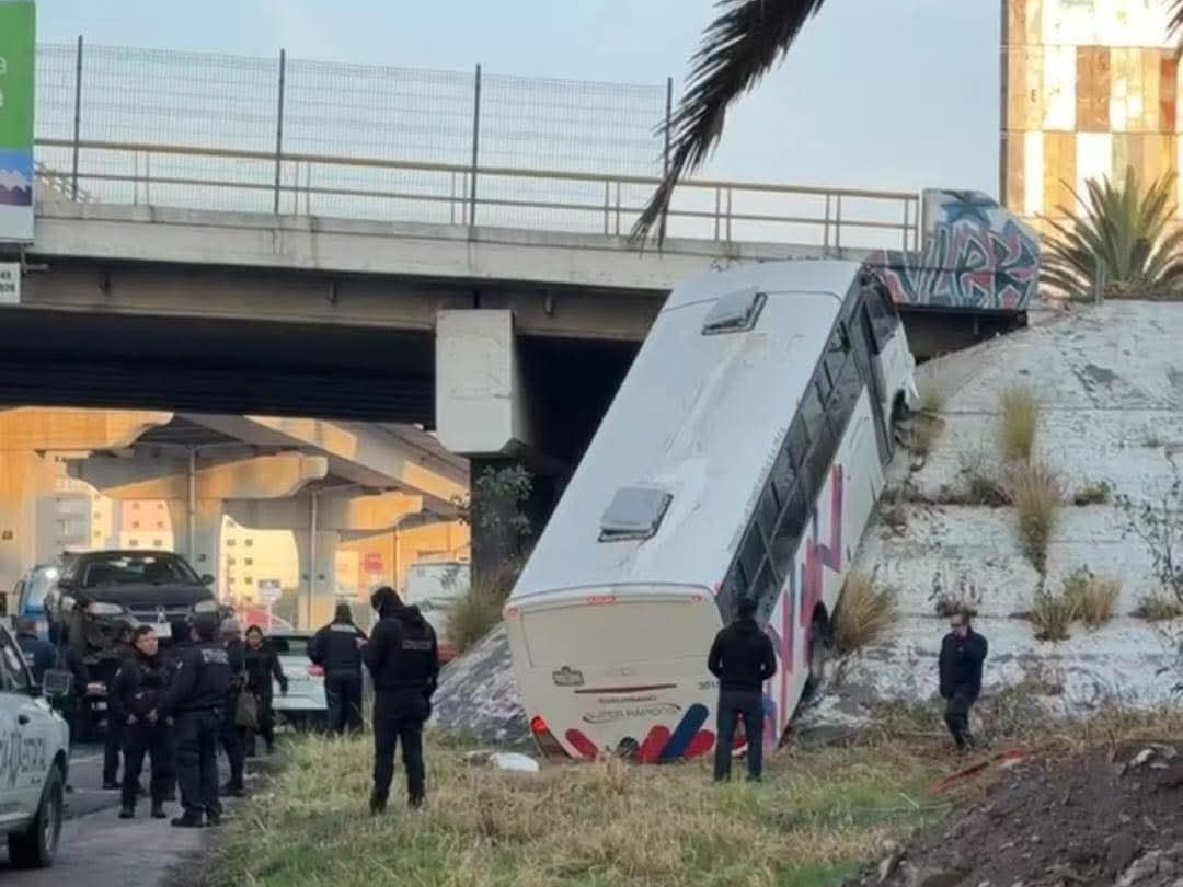 Autobús de pasajeros termina montado sobre puente de la México-Puebla